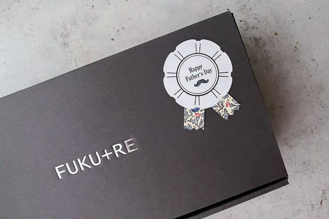 父の日用のロゼットシールが貼られた、FUKU+REの黒いギフトボックスの外観の寄り写真