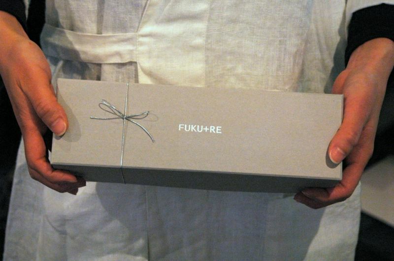 FUKU+REロゴ入りギフト箱を手に持つ様子。お礼やお返しに喜ばれる上品なお菓子ギフトボックス。